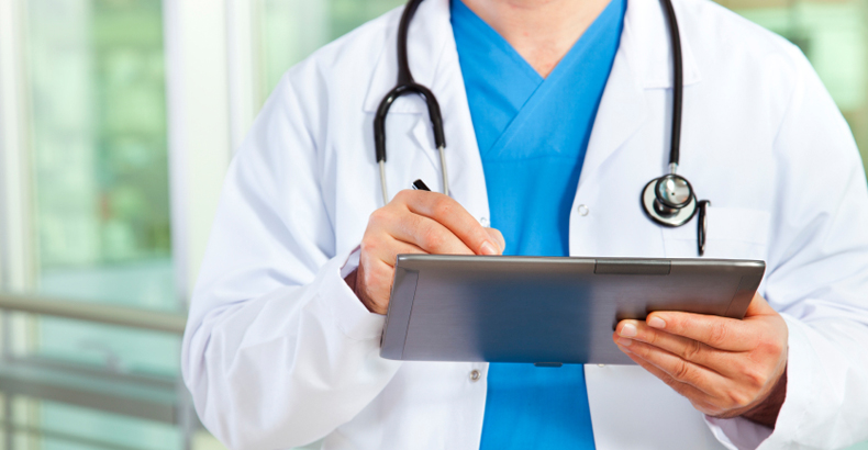 A physician writing on a clipboard