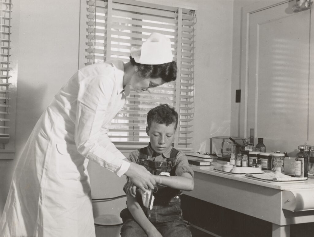 A black and white picture of a nurse taking a child's pulse