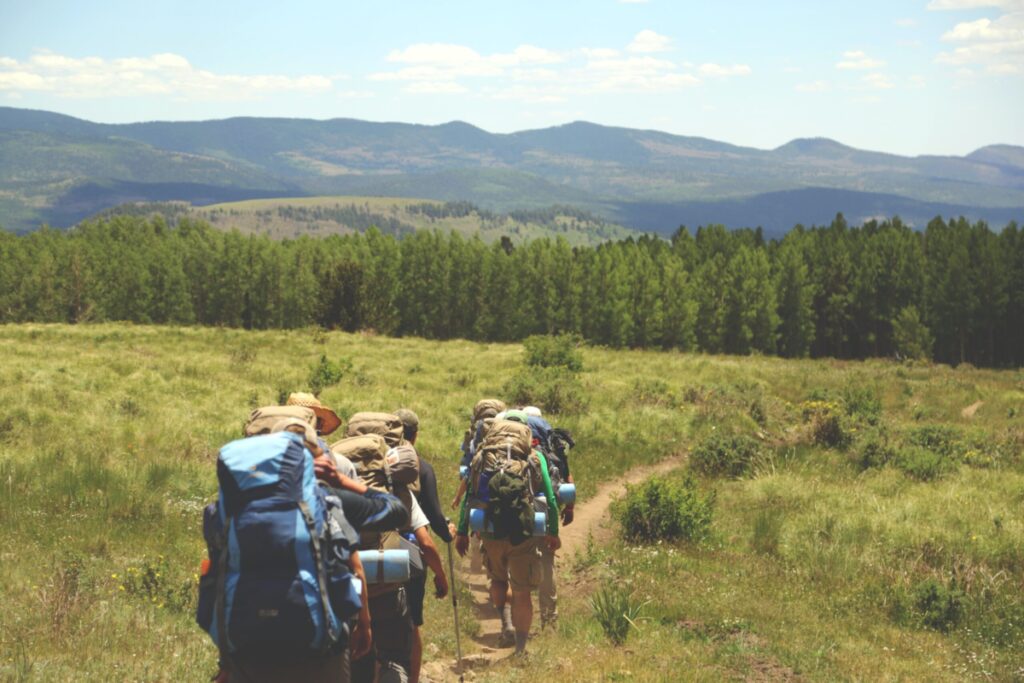 backpackers hiking across a field