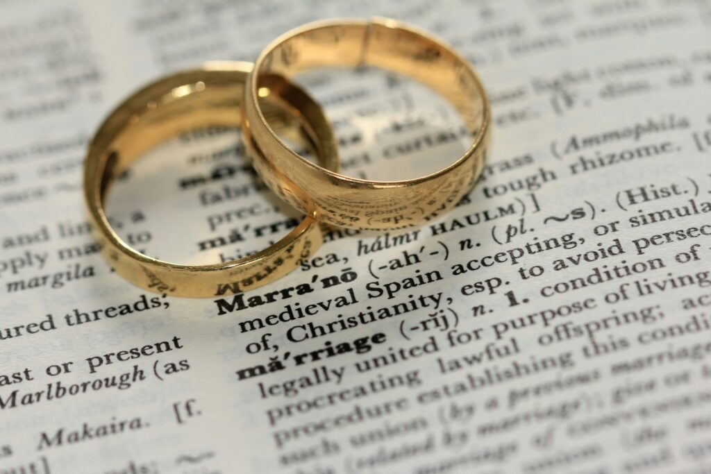 Rings on a dictionary page with the word marriage