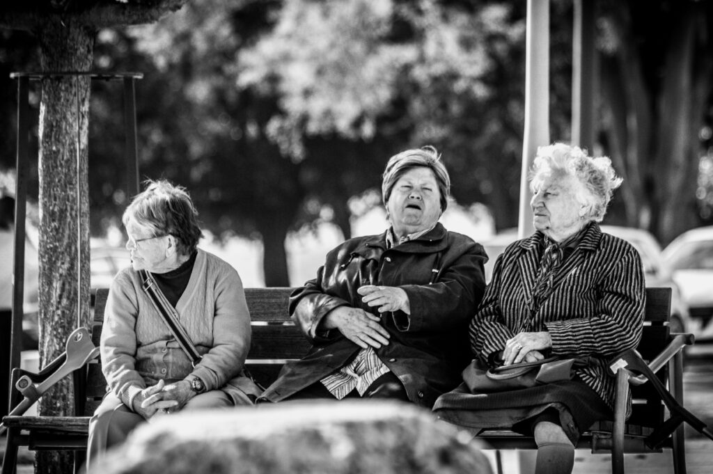 3 older women sitting on a bench